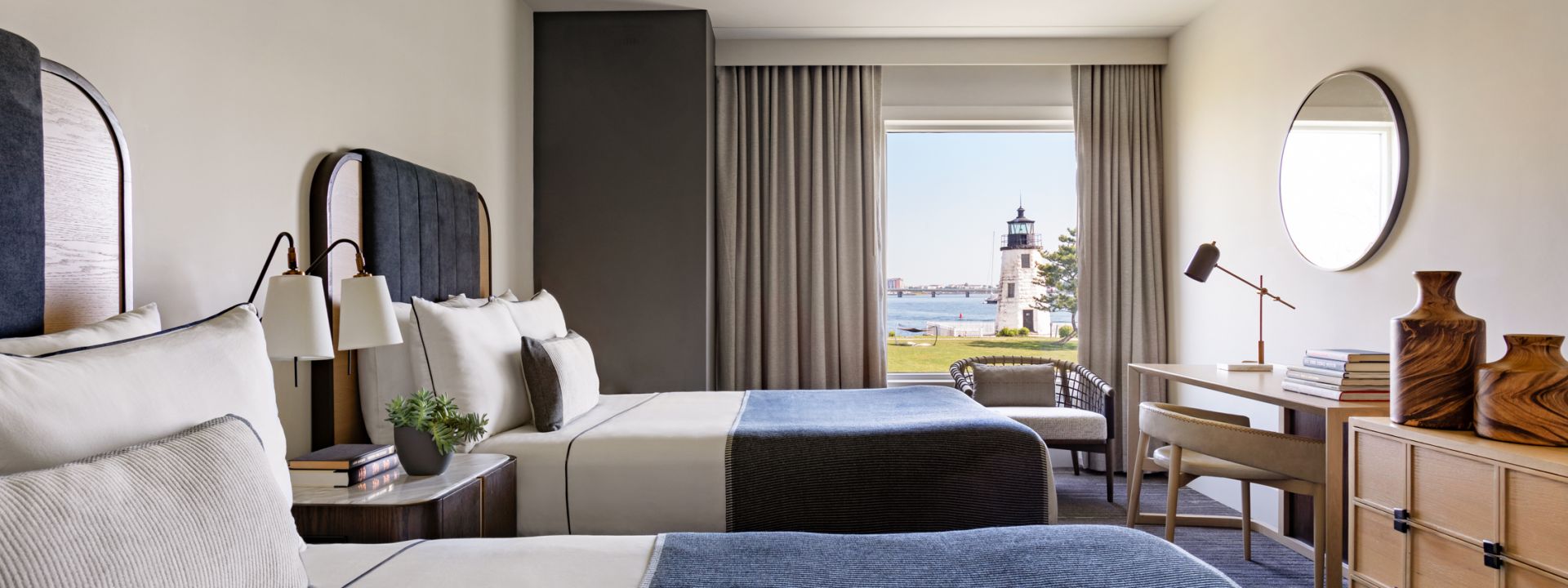 An accessible hotel room with two double beds and a waterfront view.
