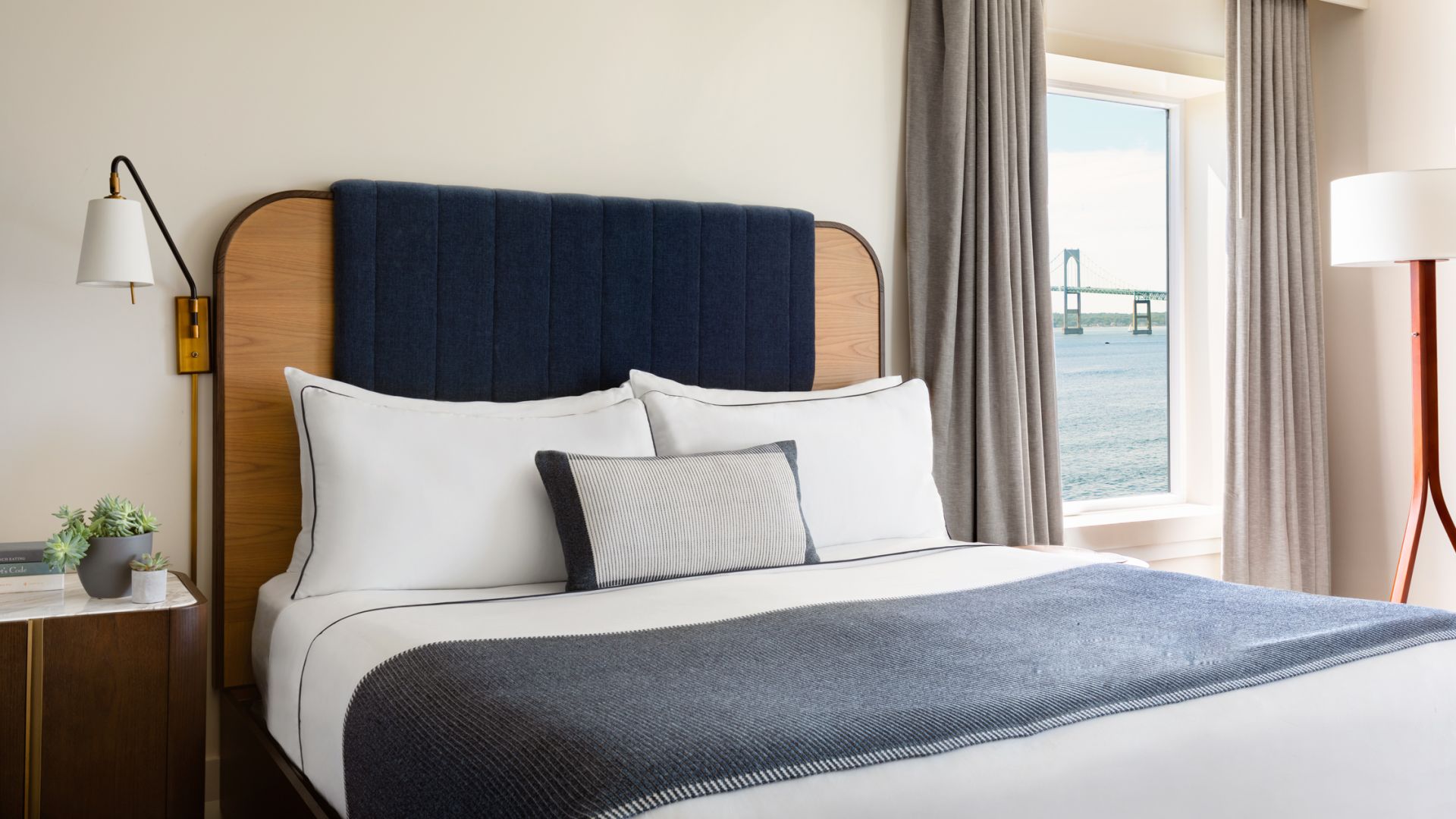 A modern hotel suite with a king bed and a harbor view.