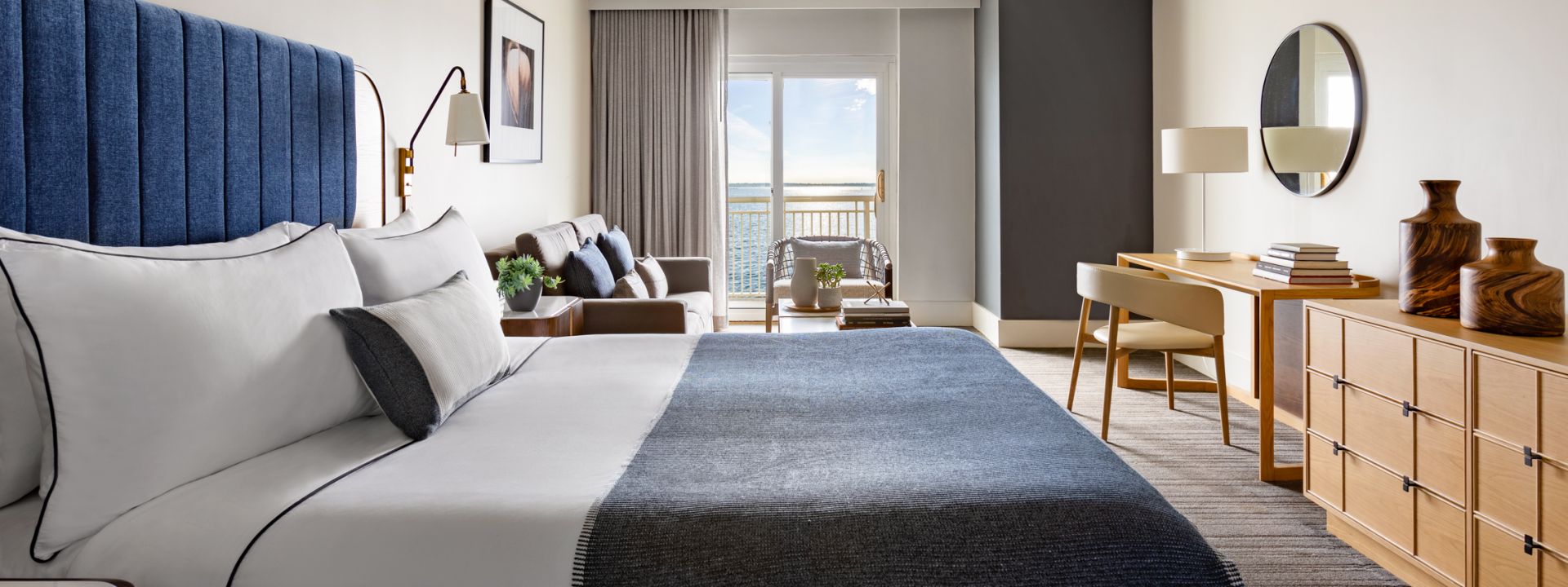 A modern hotel suite with a king bed and an ocean view.