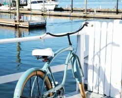 A vintage bicycle parked by a marina.