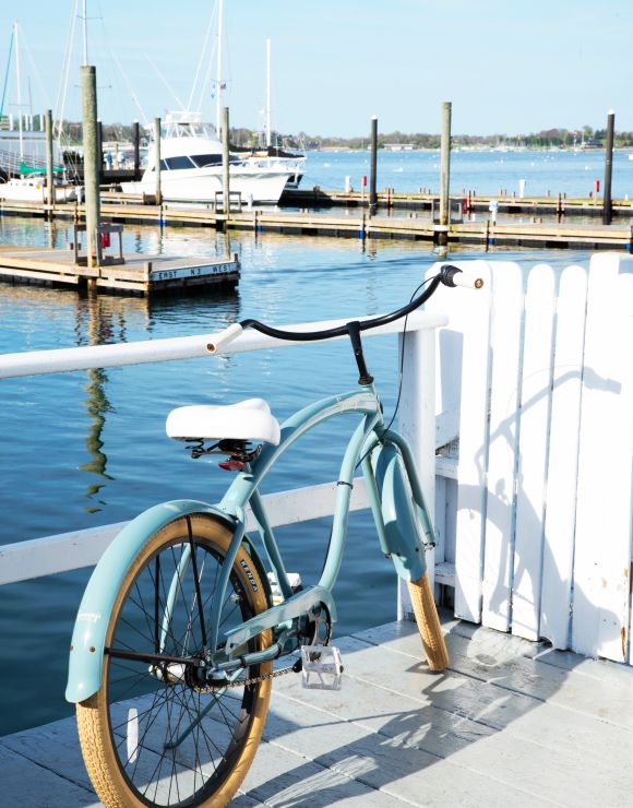A vintage bicycle parked by a marina.