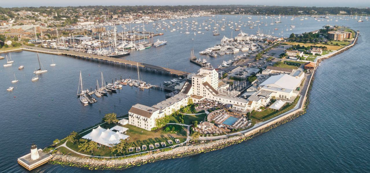 An aerial view of a large white building complex surrounded by water and boats.