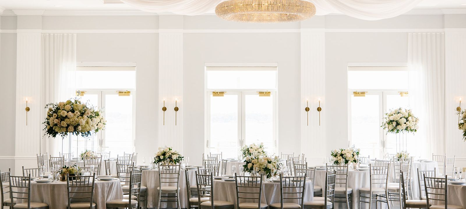 A bright and airy wedding venue decorated for a banquet.