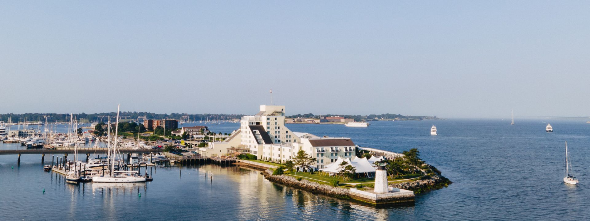 An aerial photo over the hotel showing the marina, building, and surrounding bay